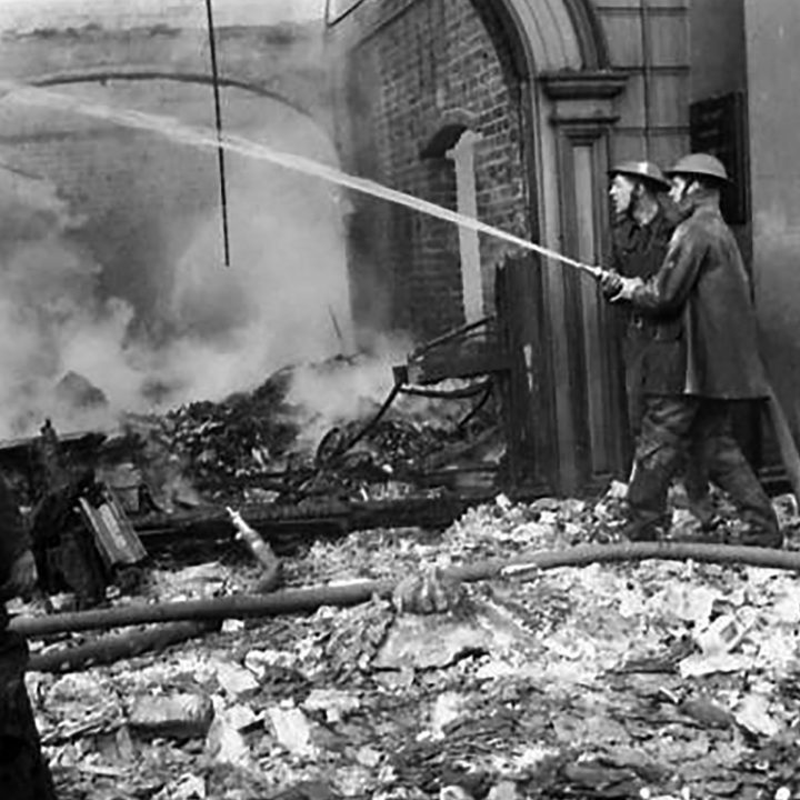 Firefighters at work dousing flames in a building following the Blitz of 16th April 1941